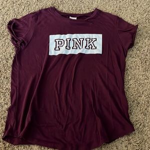 A maroon shirt sleeve tee shirt with white letters that say PINK